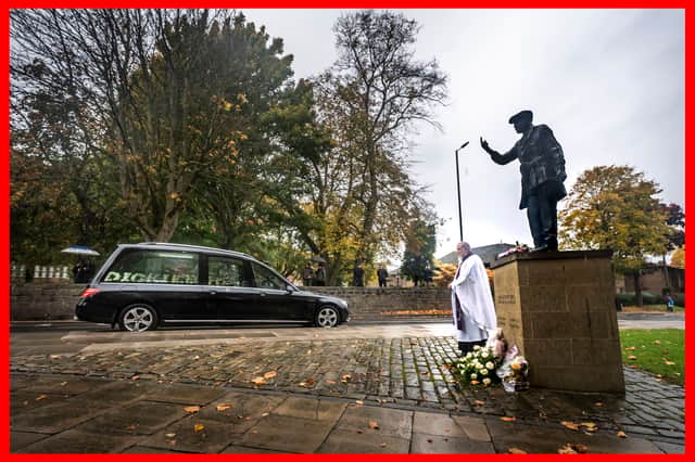 The funeral cortege for Dickie Bird passes the life-size bronze statue of Dickie Bird near St Mary's Church, Barnsley