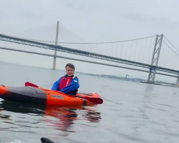 A curious dolphin swims around a group of kayakers 