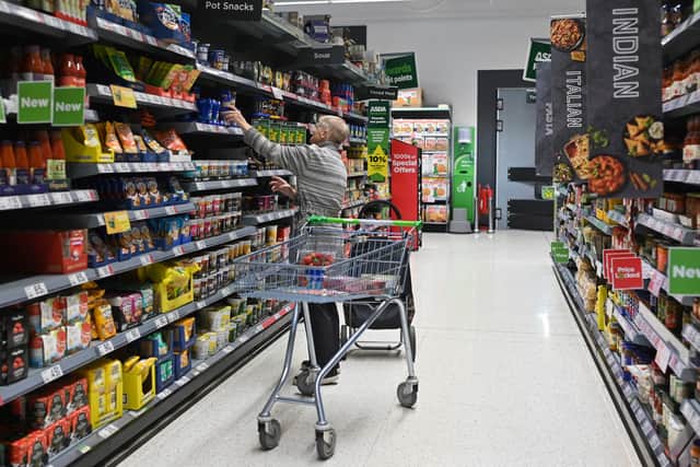 A customer looks at some goods at an Asda supermarket. The supermarket is selling 24 stores and a distribution depot in a £568m deal to boost finances (Photo: JUSTIN TALLIS/AFP via Getty Images)