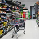 A customer looks at some goods at an Asda supermarket. The supermarket is selling 24 stores and a distribution depot in a £568m deal to boost finances (Photo: JUSTIN TALLIS/AFP via Getty Images)