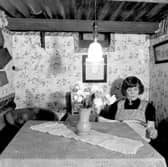 Gertrude Mabel Fawcett is pictured as she sits reading a magazine at her table in the strengthened coal cellar on Cardigan Avenue in October 1940. This air raid shelter was one of many in Leeds inspected by the A.R.P. Committee and the chairman, Councillor H. W. Sellers, praised the couple in a report which appeared in the Yorkshire Evening News.