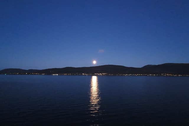 The view from the open air hot tub leaves you starry eyed as the moon rises above the coastline near Tromso.