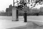 A telephone kiosk and letter box on corner of Harrogate Road and Montreal Avenue. Over the road is the Mexborough Arms public house. A young girl stands at a tram stop while a group of men are chatting by the side of the road. Pictured in July 1936.