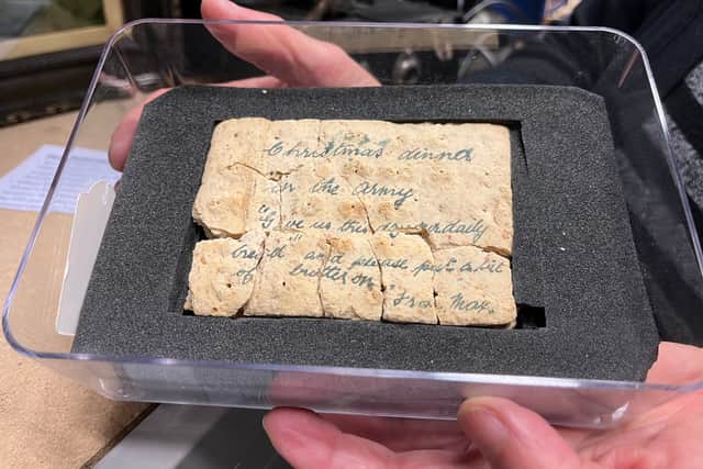 A fragile, century-old "trench biscuit" sent from the First World War front lines in 1914 by Private William Maxwell to his mother in Meanwood. Repurposed as makeshift stationery, it carries a poignant request for "a bit of butter" to accompany his army rations.