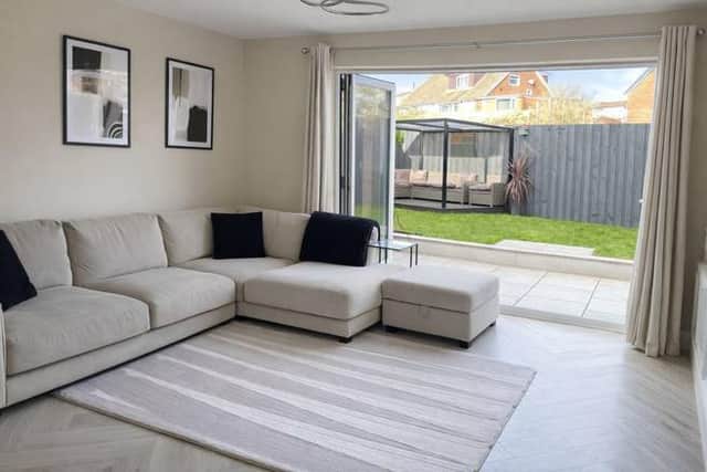 Spacious lounge with media wall and tri-fold doors to the garden