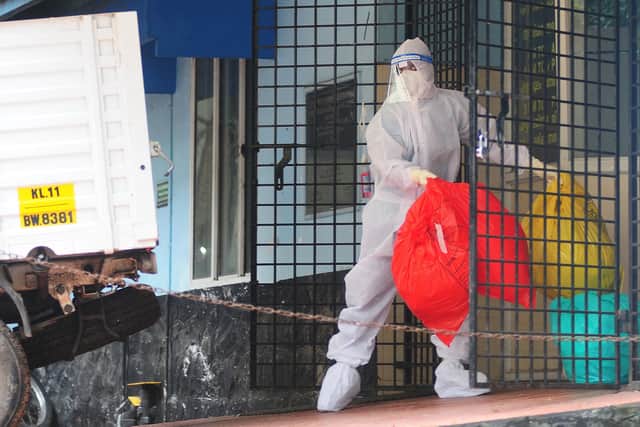 A health worker wearing protective gear disposes of biohazard waste from a Nipah virus isolation centre.
