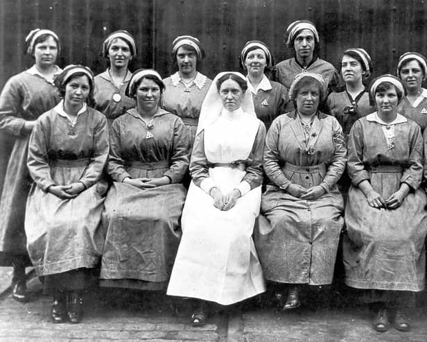  A group of munitions workers and a nurse. The women are wearing protective clothing, munition work was dirty and dangerous.