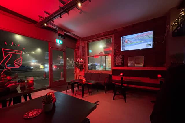 Floor-to-ceiling windows and red neon light sets the tone.