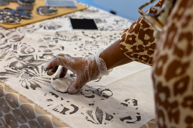   A group from Leeds Asylum Seekers’ Support Network printing fabric with stamps made from Victorian Burmantofts tiles in the University of Leeds’ Great Hall.  