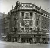 Odeon cinema & cafe-restaurant on The Headrow. It is showing 'Black Narcissus' film in Technicolor, 'Concurrent with London World Premiere' featuring Deborah Kerr and Sabu. Next door are Mecca Models and Meesons High Class Confectioners.