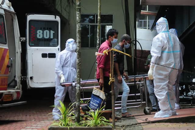 Health workers wearing protective gear move people who have been in contact with a person infected with the Nipah virus to an isolation centre.