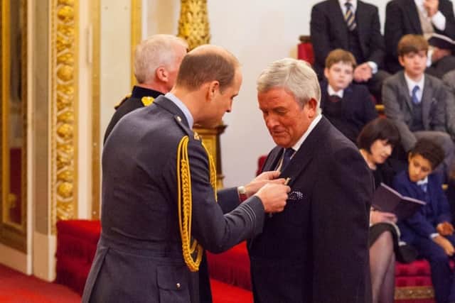 Mike Davies receiving his MBE from Prince William in 2017