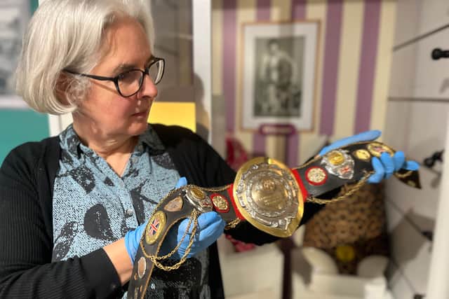 Kitty Ross, Leeds Museums and Galleries’ curator of social history, is pictured with a belt once worn by the city’s own female wrestler Sue Brittain, later known to opponents as Lady Satan.