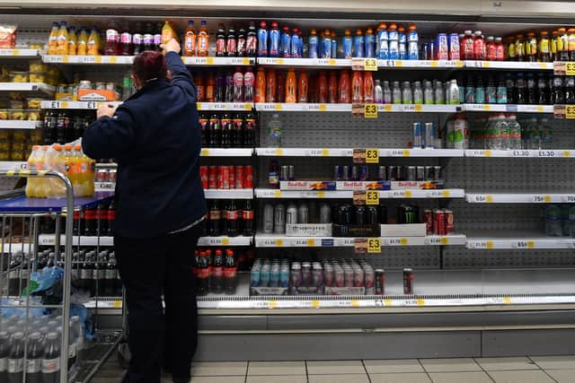 An employee stocks shelves at a Tesco supermarket. The retailer is increasing hourly pay for store and warehouse staff by 5.1% from March 29 (Photo: JUSTIN TALLIS/AFP via Getty Images)