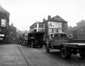 Looking north onto Briggate in November 1949. The nearest lorry and van have signs for 'J. Marsland & Sons Ltd.' and 'Tapp & Toothill Limited' on them respectively. A number 10 tram to Compton Road is visible.