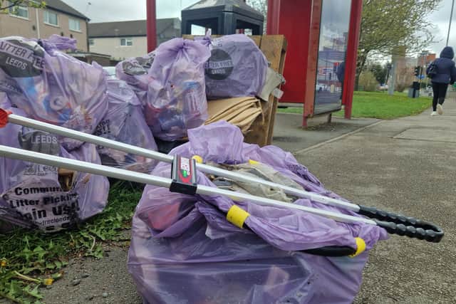 Purple bags of rubbish collected along Tong Road.