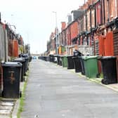 Wheelie bins lined up in a back street in Leeds.