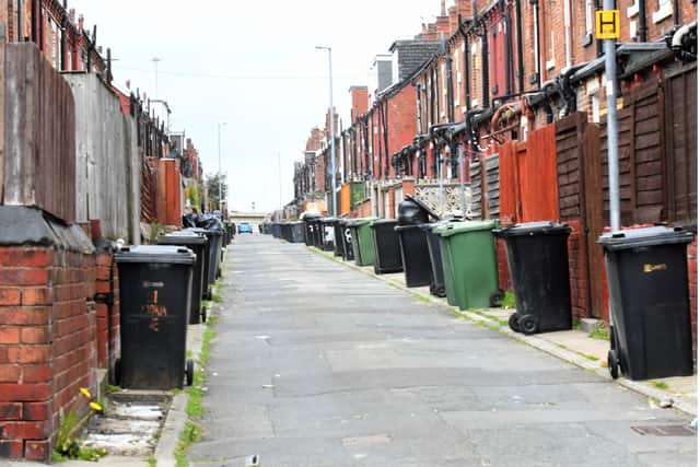Wheelie bins lined up in a back street in Leeds.
