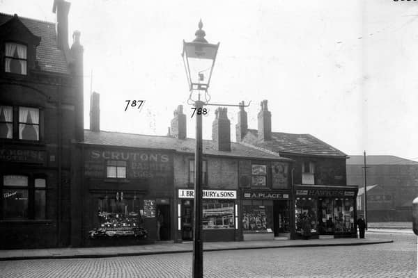 Bensons Place, a cobbled street off Belle Isle Road, pictured in  December 1935. The Bay Horse Hotel, Wilfred Gavins greengrocers, J. Bradbury and Sons pork butchers, Arthur Place boot and shoe maker, Arthur James Hawkes draper and the Cooperative Wholesale Society Brush factory are shown.