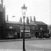 Bensons Place, a cobbled street off Belle Isle Road, pictured in  December 1935. The Bay Horse Hotel, Wilfred Gavins greengrocers, J. Bradbury and Sons pork butchers, Arthur Place boot and shoe maker, Arthur James Hawkes draper and the Cooperative Wholesale Society Brush factory are shown.