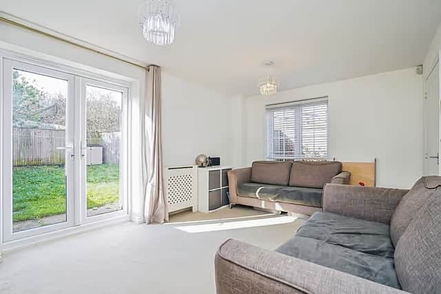 French doors in the living room open straight onto the enclosed rear garden