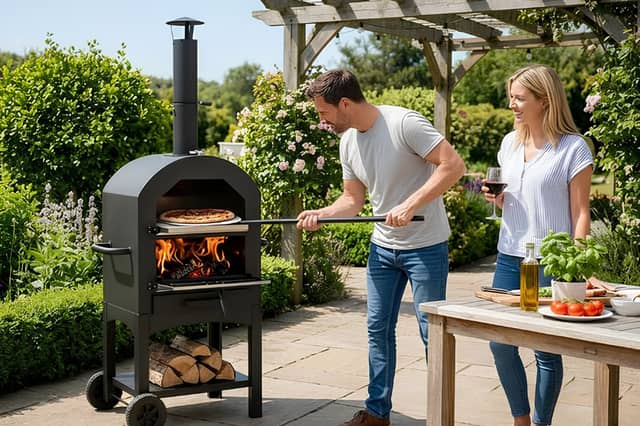 The portable outdoor pizza oven bundle includes a pizza stone, peel, cutter and integrated thermometer for garden cooking