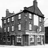 The Albion pub on Armley Road pictured in October 1963. This public house with its column's and tiled facade is a Tetley house, and the Tetley huntsman logo is visible on the wall. On the left of the photo is Brunel Street. On the far right is Arkwright Street.