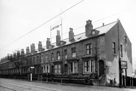 A row of terraced houses from 338 (end house on right) to 360 Meanwood Road. Number 342 is labelled. A sign for Dermide Ltd. leather cloth manufacturers is on the right. A tram stop and pillar box can be seen and there are tram lines in the road. Pictured in November 1946.