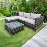 The rattan garden furniture set includes cushioned seating, ottoman stools and a tempered glass table.