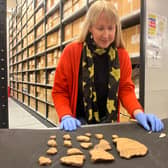 Kat Baxter, Leeds Museums and Galleries’ curator of archaeology, with ancient artefacts discovered inside a Bronze Age burial mound in Leeds.