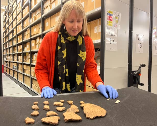Kat Baxter, Leeds Museums and Galleries’ curator of archaeology, with ancient artefacts discovered inside a Bronze Age burial mound in Leeds.