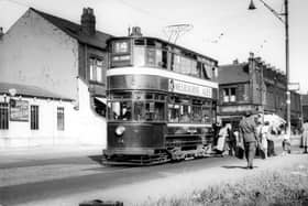 Passengers alighting from tram no.114 at a stop on Stanningley Road. The Station Garage is on the left. To the right of the tram is Bramley Home Bakeries at the junction with Hough Lane. Pictured in August 1952.