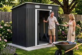 The charcoal black metal shed is designed to bring practical storage and a more modern look to outdoor spaces