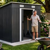 The charcoal black metal shed is designed to bring practical storage and a more modern look to outdoor spaces