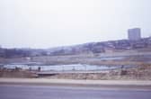 Looking from Tong Road onto a site being developed into a reservoir, bordered by Ring Road, Farnley on the left, Butt Lane at the far end, and Pudsey Road on the right. Pictured in March 1973.