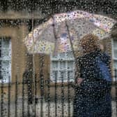 A woman passes a window covered in rain drops on 6 October 2014 in Bath, England.