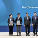 John Lee (centre) witnesses the exchange of memoranda between organisations from both sides.