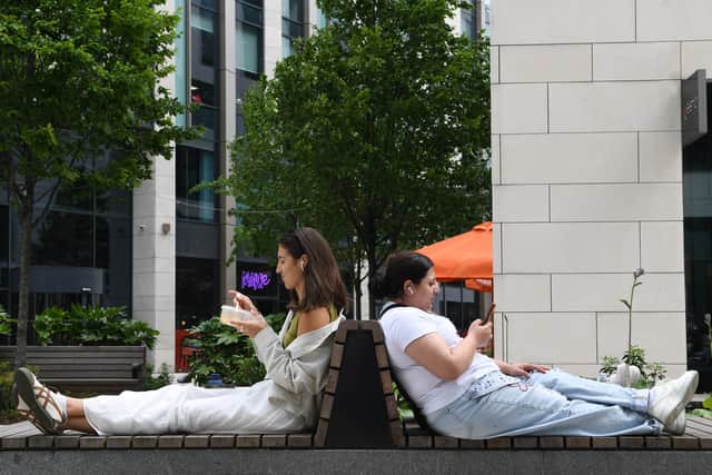 People enjoy their lunch break in the sunshine at Wellington Place, Leeds
Picture Gerard Binks