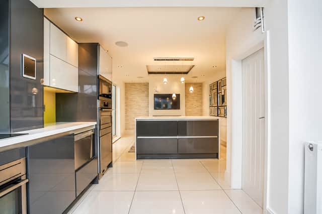 A large central island takes pride of place in the contemporary kitchen diner, creating a sociable setting for cooking and entertaining