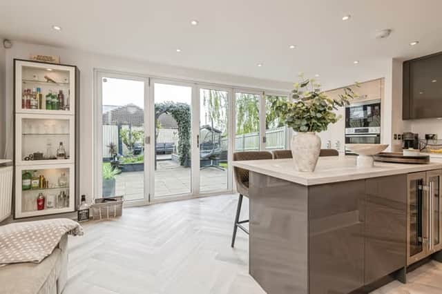 The sleek open-plan kitchen is the heart of the house, designed for busy family life and entertaining with bi-fold doors leading straight out to the garden.