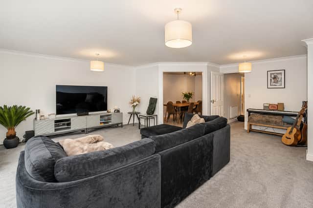 The spacious first-floor lounge looks towards the woodland and opens to a Juliet balcony above the private rear garden.