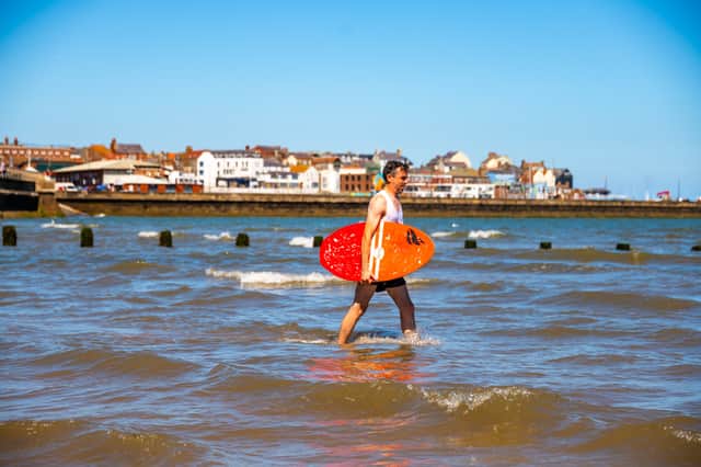 A skimboarder heads into the sea at Bridlington