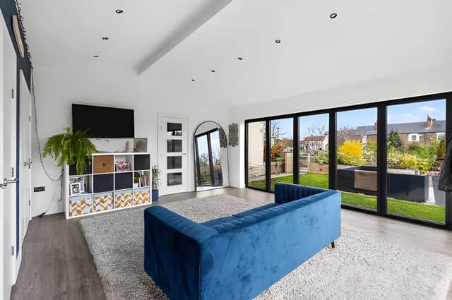 High ceilings and exposed beams help create a bright, welcoming living space full of character.