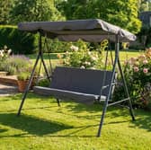 The grey three-seater garden swing chair includes padded cushions and an adjustable canopy for outdoor seating