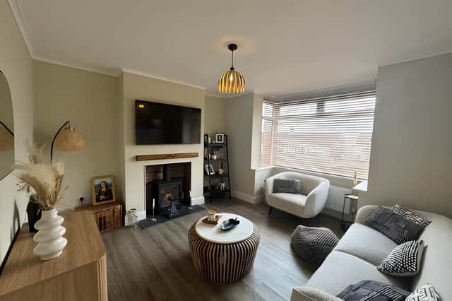 The elegant lounge features a charming bay window and a wood-burning stove, creating a warm, cosy space to relax in.