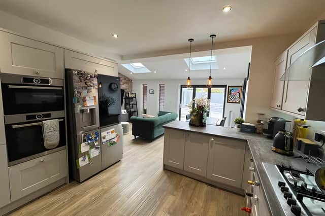 The sleek, contemporary kitchen has integrated appliances and room for a full-size dining table