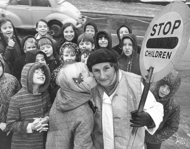 Sally Bowers, aged nine, plants a kiss on the cheek of lollipop lady Mary Thrippleton, aged 70, who has completed 20 years as a lollipop lady outside New Park Primary School, Harrogate, in December 1973