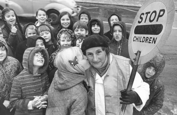 Sally Bowers, aged nine, plants a kiss on the cheek of lollipop lady Mary Thrippleton, aged 70, who has completed 20 years as a lollipop lady outside New Park Primary School, Harrogate, in December 1973
