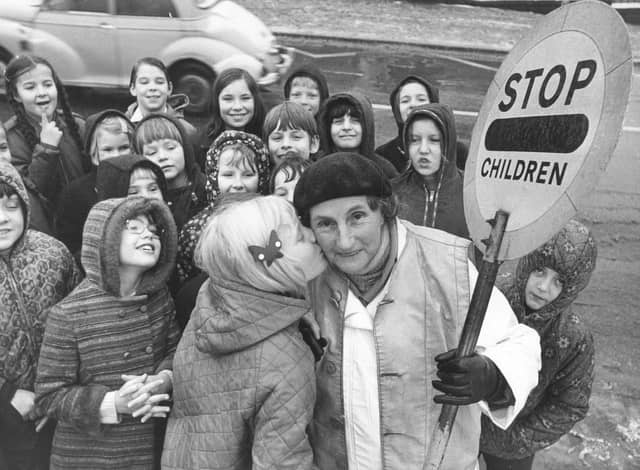 Sally Bowers, aged nine, plants a kiss on the cheek of lollipop lady Mary Thrippleton, aged 70, who has completed 20 years as a lollipop lady outside New Park Primary School, Harrogate, in December 1973