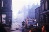 A fire engine and crew at work to extinguish the blaze which spread through the Town Hall in August 1961 after starting in Albert Mills behind.